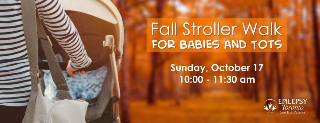 a parent pushes a stroller towards a forest path of orange leaved trees