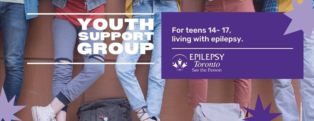The legs of people in jeans and ripped track pants, with backpacks, leaning against a brick wall.