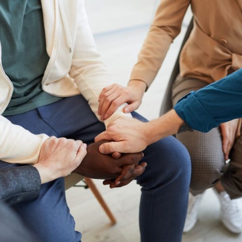people holding hands at support group