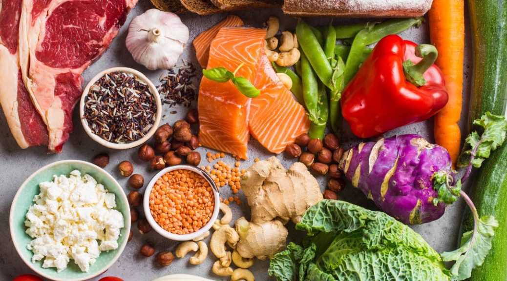 An assortment of healthy food including: meat, cheese, vegetables, fish, nuts, beans and more.